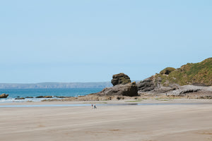 Broad Haven beach scene at low tide, with rocks and a clear sky
