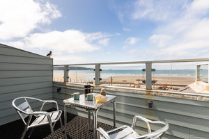 Private outdoor balcony with table and chairs overlooking Broad Haven beach.