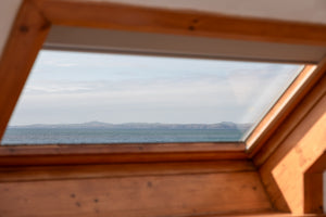 Wooden window frame with a view of mountains and Broad Haven beach.